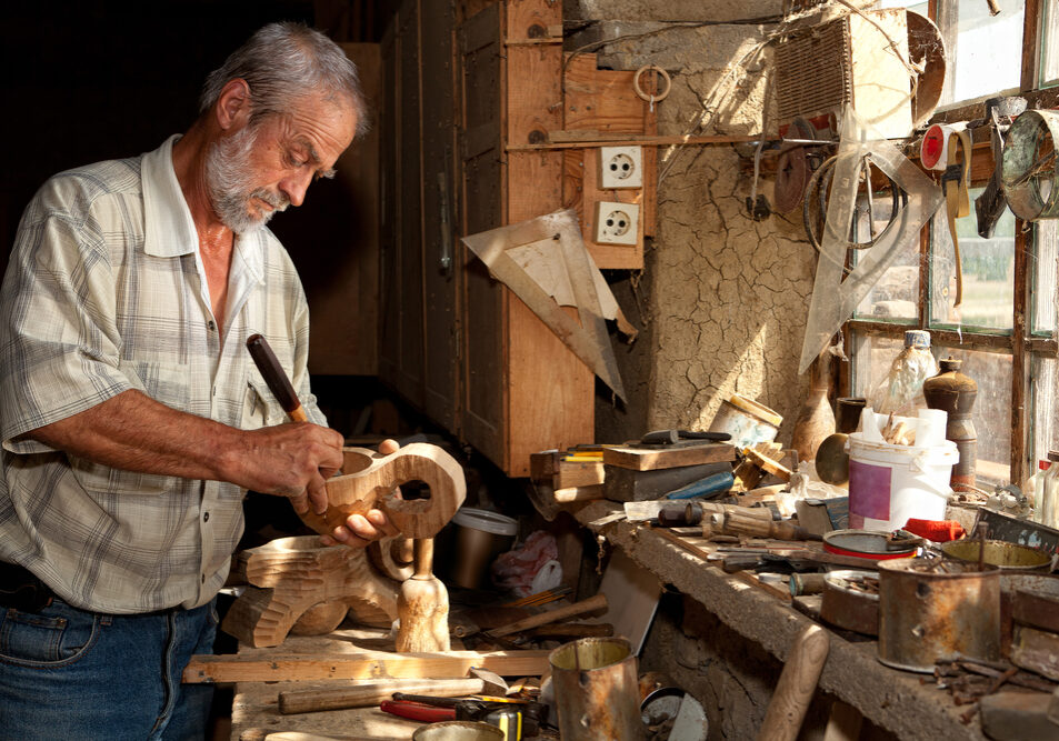 Wood,Worker,Carving,Wood,In,A,Derelict,Shed